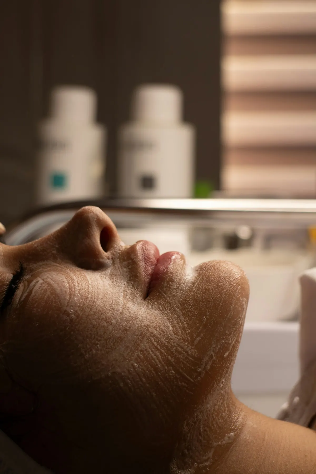 A guest's face covered in cleansing foam during a double cleansing facial