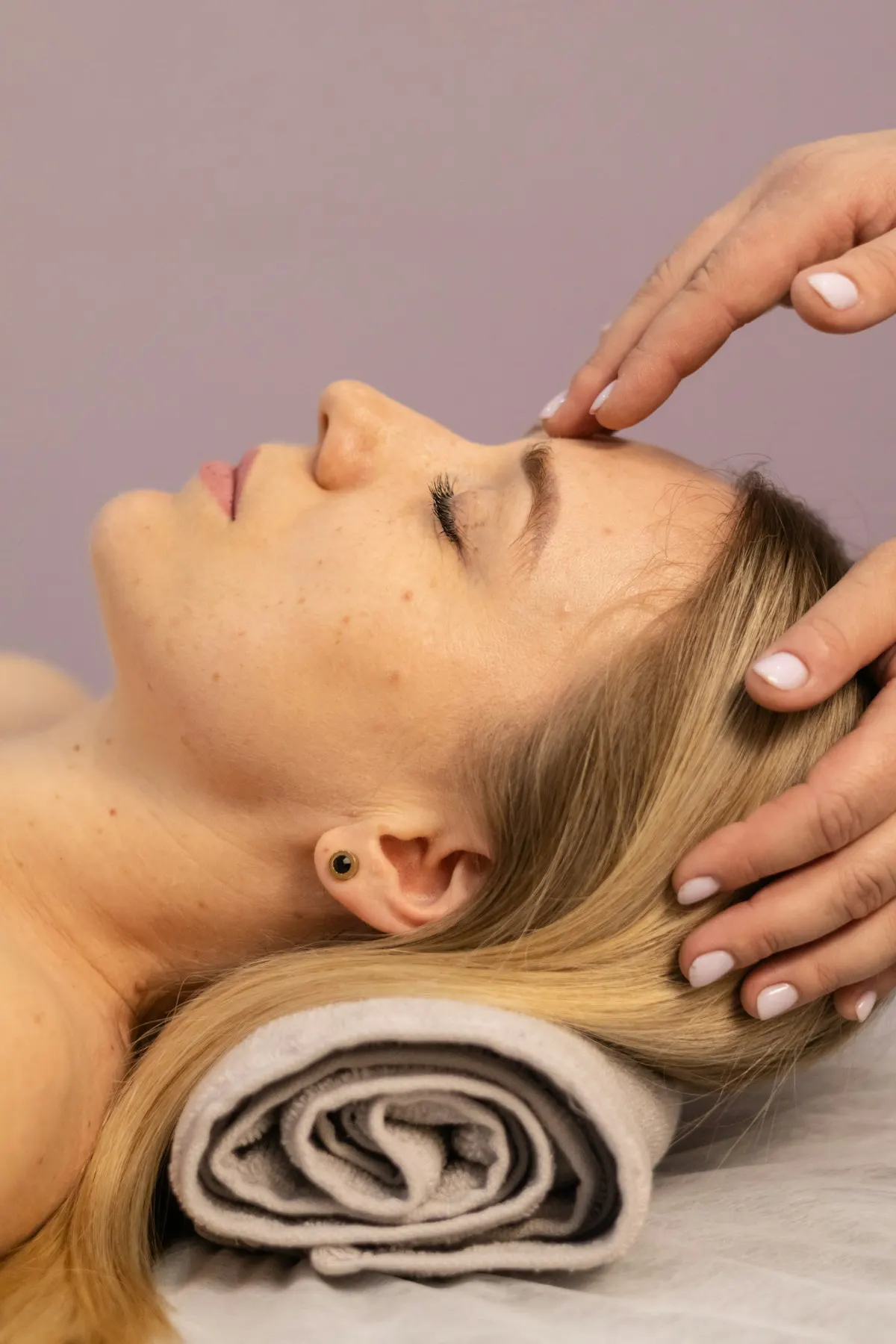 A therapist massages a guest's temples during a lifting facial