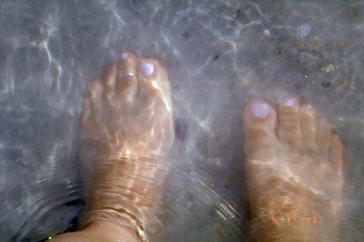 Feet soaking in clear water before a pedicure